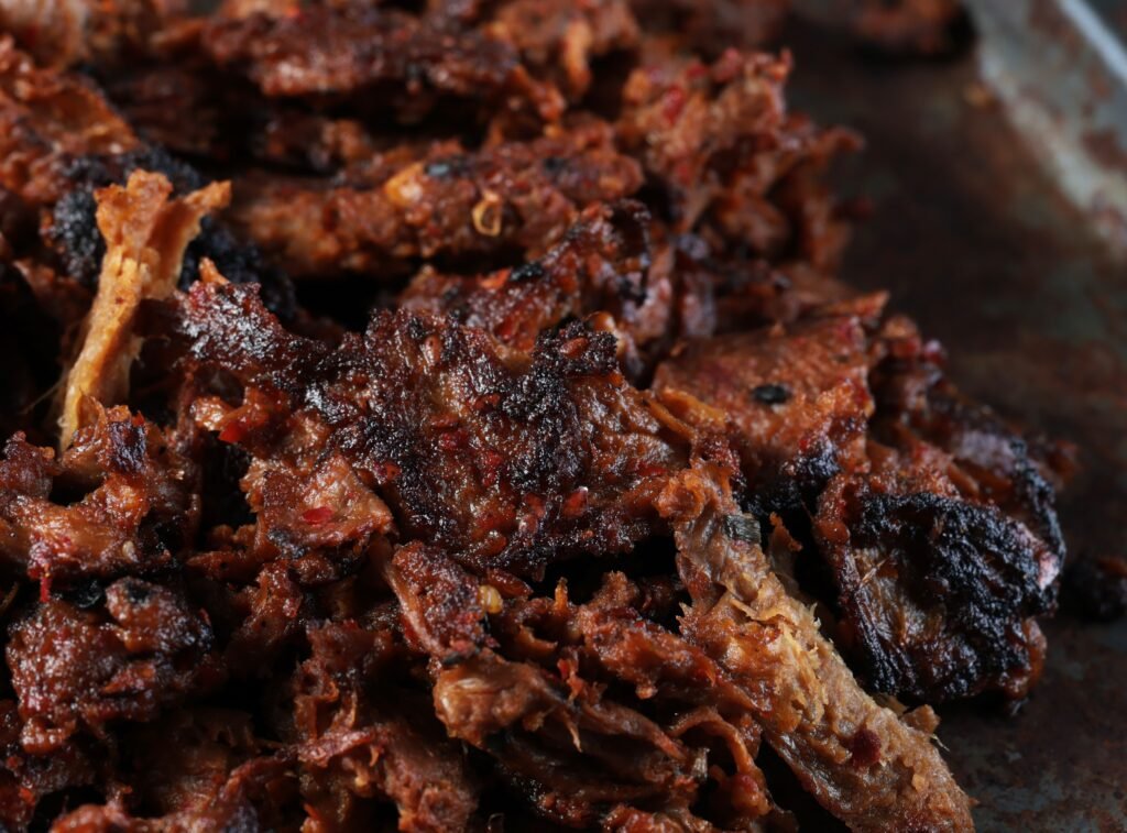 Harvest Shreds in pan tight crop square Close up of Harvest Shreds resembling shredded meat, with bits of char.